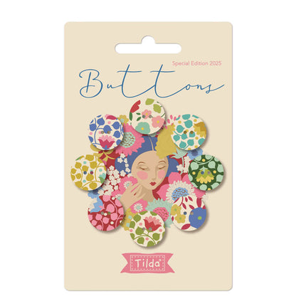 Packaging of Tilda Wallflower Buttons featuring 8 fabric covered buttons in red and green floral patterns on a card with the brand name and a part of the design visible.
Photo by Tildafabrics.com [image_link]