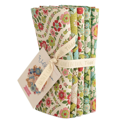 Five fat quarter bundles of Tilda Wallflower fabric with floral patterns in various green colors, tied together with a tag displaying the brand and product name.
Photo by Tildafabrics.com [image_link]
