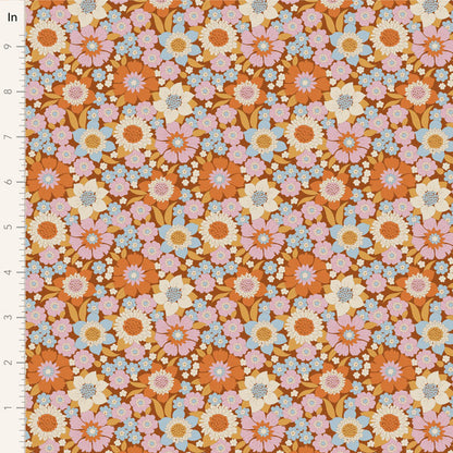 Yardage of floral print fabric in caramel, blue, ginger, ochre, and thistle colors with a 1-inch scale bar on the side.
Photo by Tildafabrics.com [image_link]