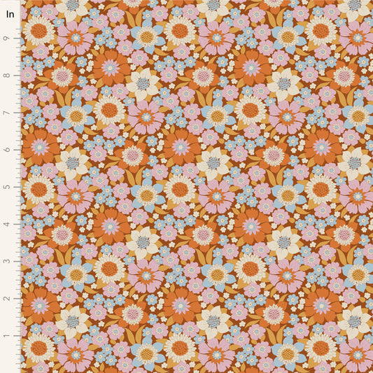Yardage of floral print fabric in caramel, blue, ginger, ochre, and thistle colors with a 1-inch scale bar on the side.
Photo by Tildafabrics.com [image_link]
