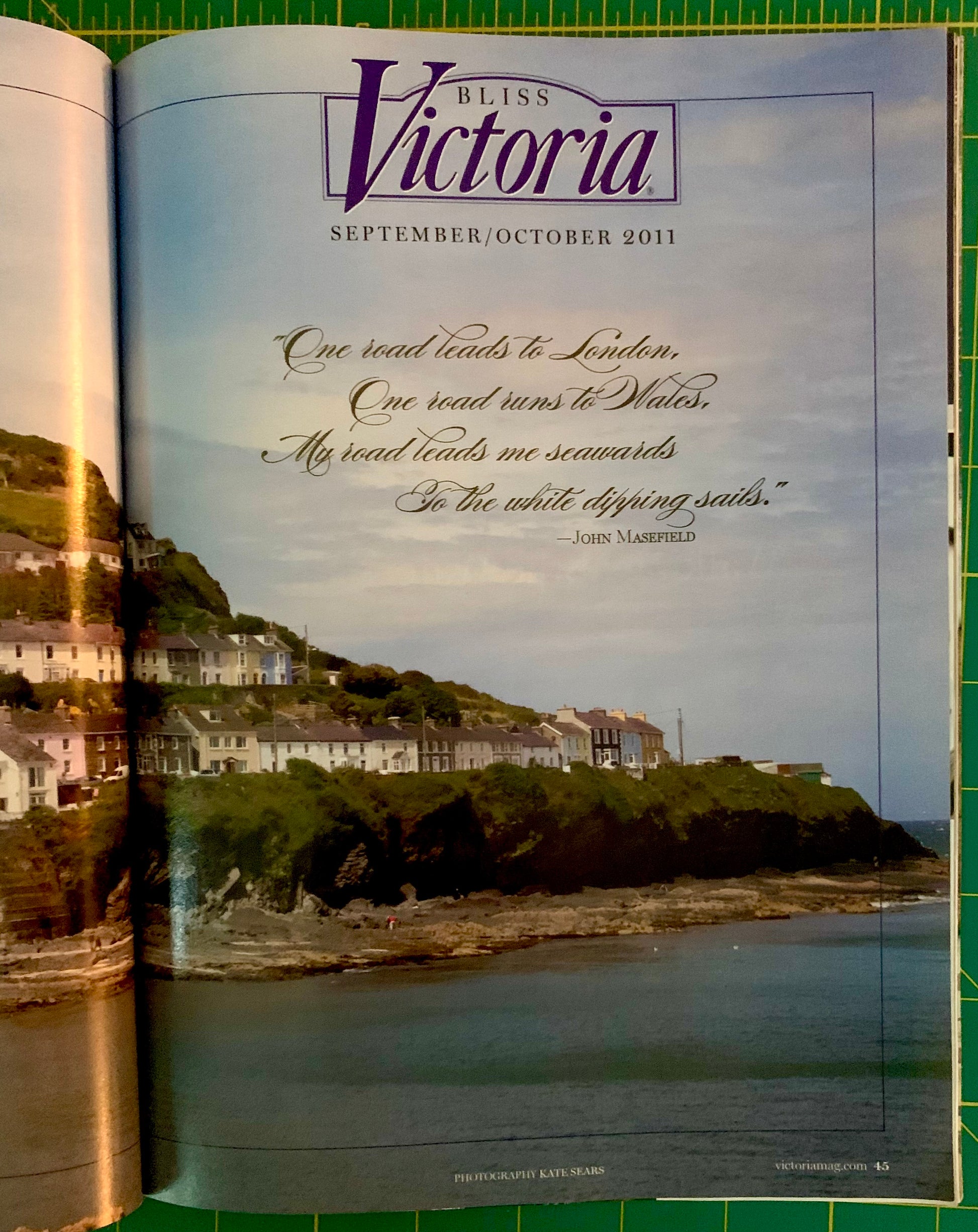 An open magazine or book spread showing the cover of Bliss Victoria September/October 2011. The page features a coastal landscape photograph with houses on a cliffside, a quote by John Masefield, and the Bliss Victoria title at the top.
[additional_image_link]