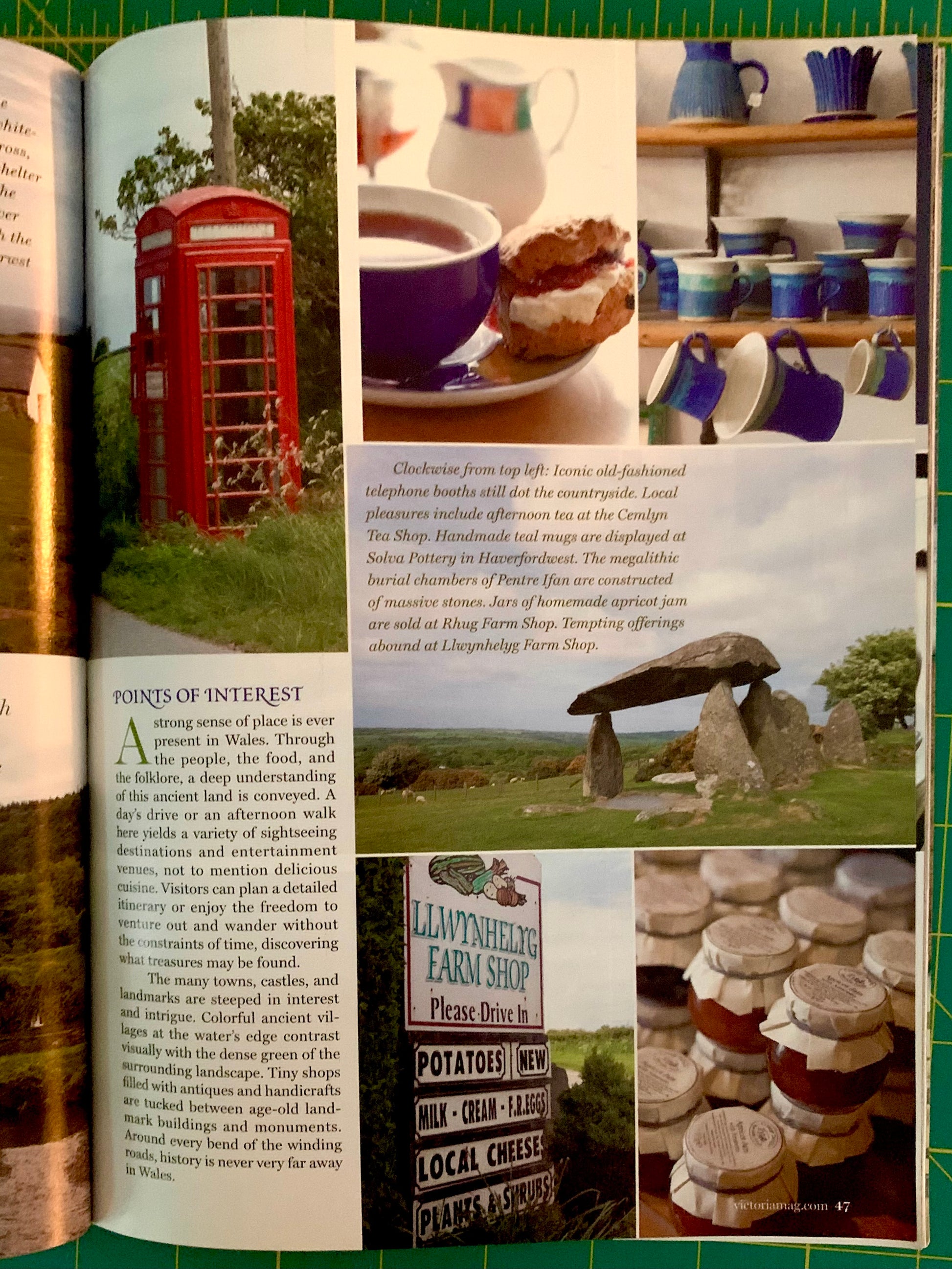 An open magazine or book spread showing travel and shopping articles, with multiple inset photos of blue-and-white ceramic mugs, a red telephone booth, and a sign for 'Lallywheiler Farm Shop' on a green cutting mat background.
[additional_image_link]