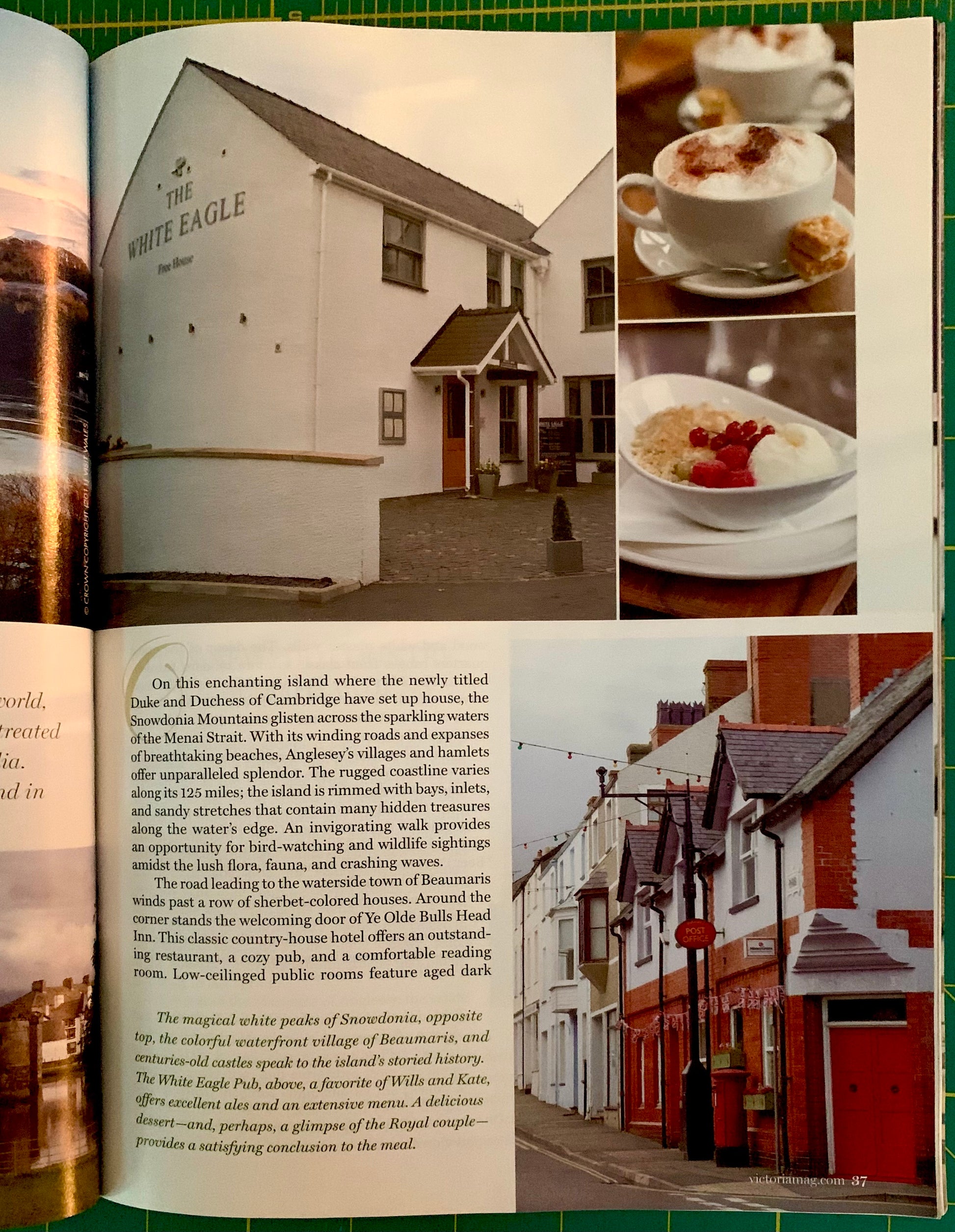 An open book spread showing a travel article about White Eagle in Scotland, with black-and-white and color photographs of a large white building, a red-and-white building, and a cup of cappuccino with a strawberry dessert.
[additional_image_link]
