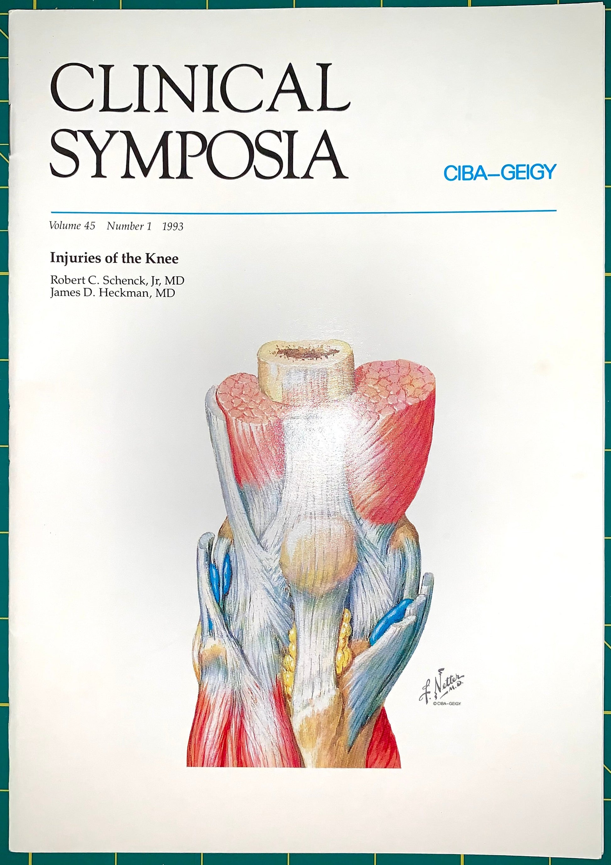 A vintage medical journal cover titled 'CLINICAL SYMPOSIA' with an anatomical illustration of knee injuries in the center, photographed against a green grid background.
[additional_image_link]