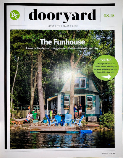 Front cover of the Dooryard magazine, August 2023 issue, featuring a large photograph of 'The Funhouse' cottage on a lake surrounded by trees and patio chairs. The masthead 'dooryard' is visible at the top, along with the issue date '08.
[additional_image_link]