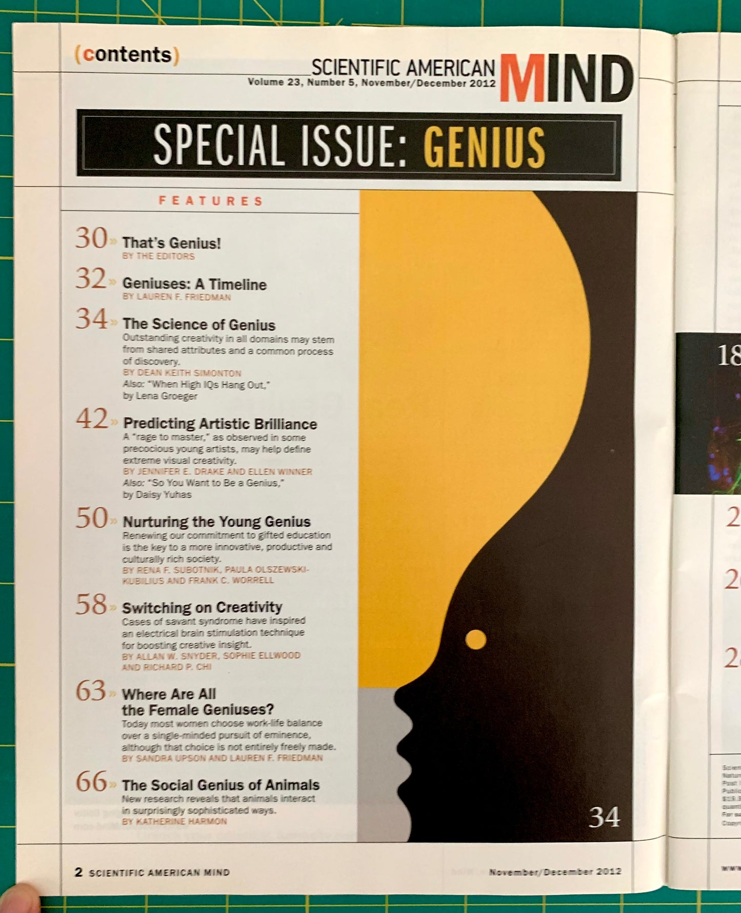 An open copy of Scientific American Mind magazine, showing the front cover with the headline 'Special Issue: Genius' and a large black-and-gold silhouette graphic on a white page. The magazine is photographed on a green grid cutting mat.
[additional_image_link]