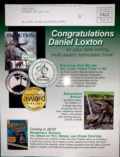 A printed congratulatory card for Daniel Loxton featuring multiple book covers, award seals, and text for his multi-award nominated book 'Evolution: How We and All Living Things to Come.' The card has a green-to-blue gradient background with several inset book covers and circular award badges.
[additional_image_link]