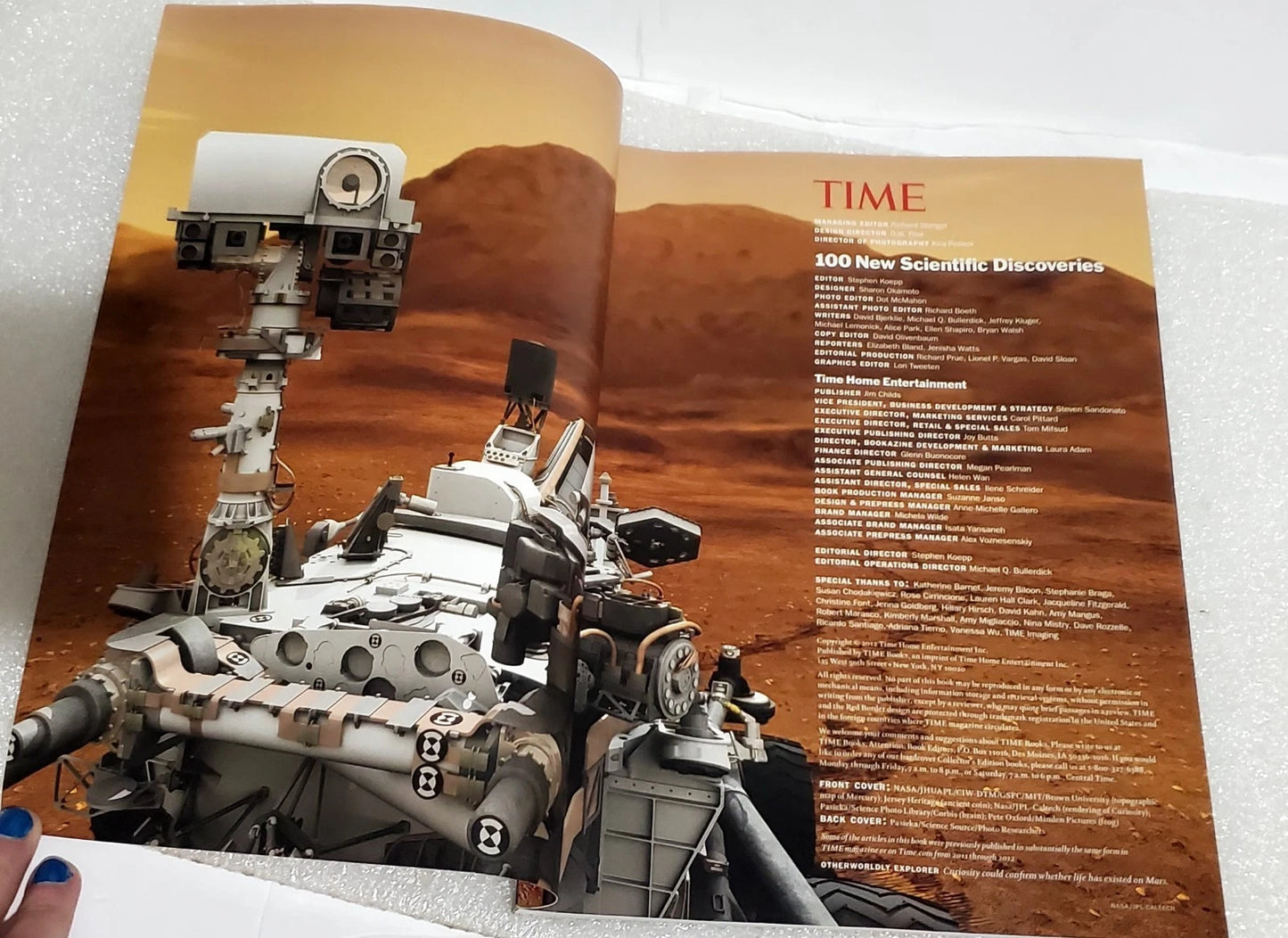 An open TIME magazine spread featuring a large cover photo of a Mars rover in a reddish desert landscape, with the TIME logo and article text on the right page.
[additional_image_link]