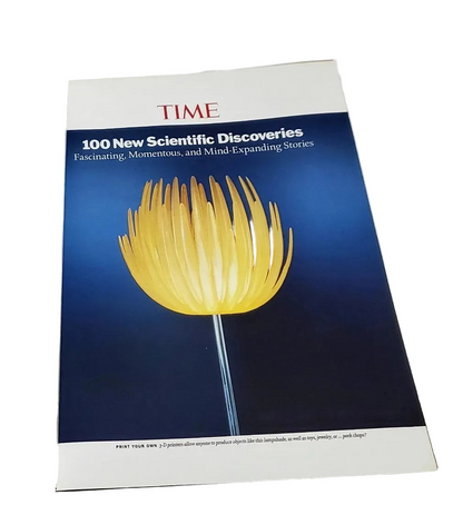 A TIME magazine cover featuring a glowing yellow flower against a dark blue background, photographed on a plain white surface.
[additional_image_link]