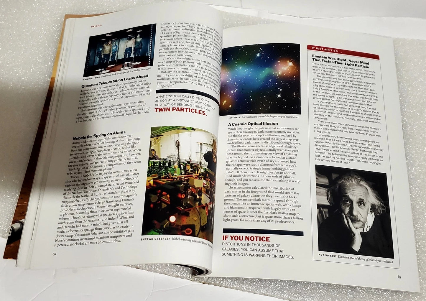 An open magazine or book spread showing multiple printed articles with text, small photos, and one larger space-themed image on the right page, photographed on a light textured surface.
[additional_image_link]