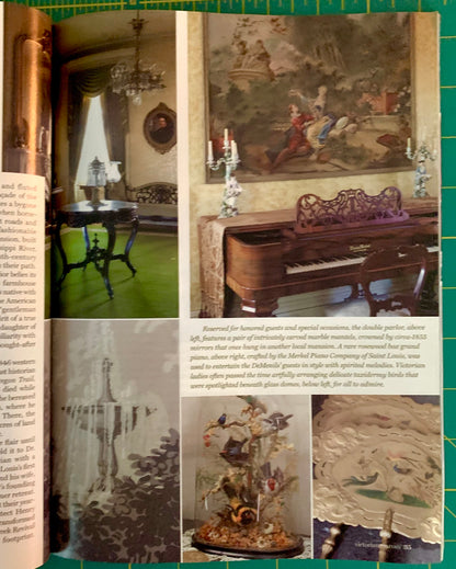 An open book or magazine spread showing a vintage interior photograph collage with an ornate piano, chandelier, table, and decorative objects, photographed on a green cutting mat.
[additional_image_link]