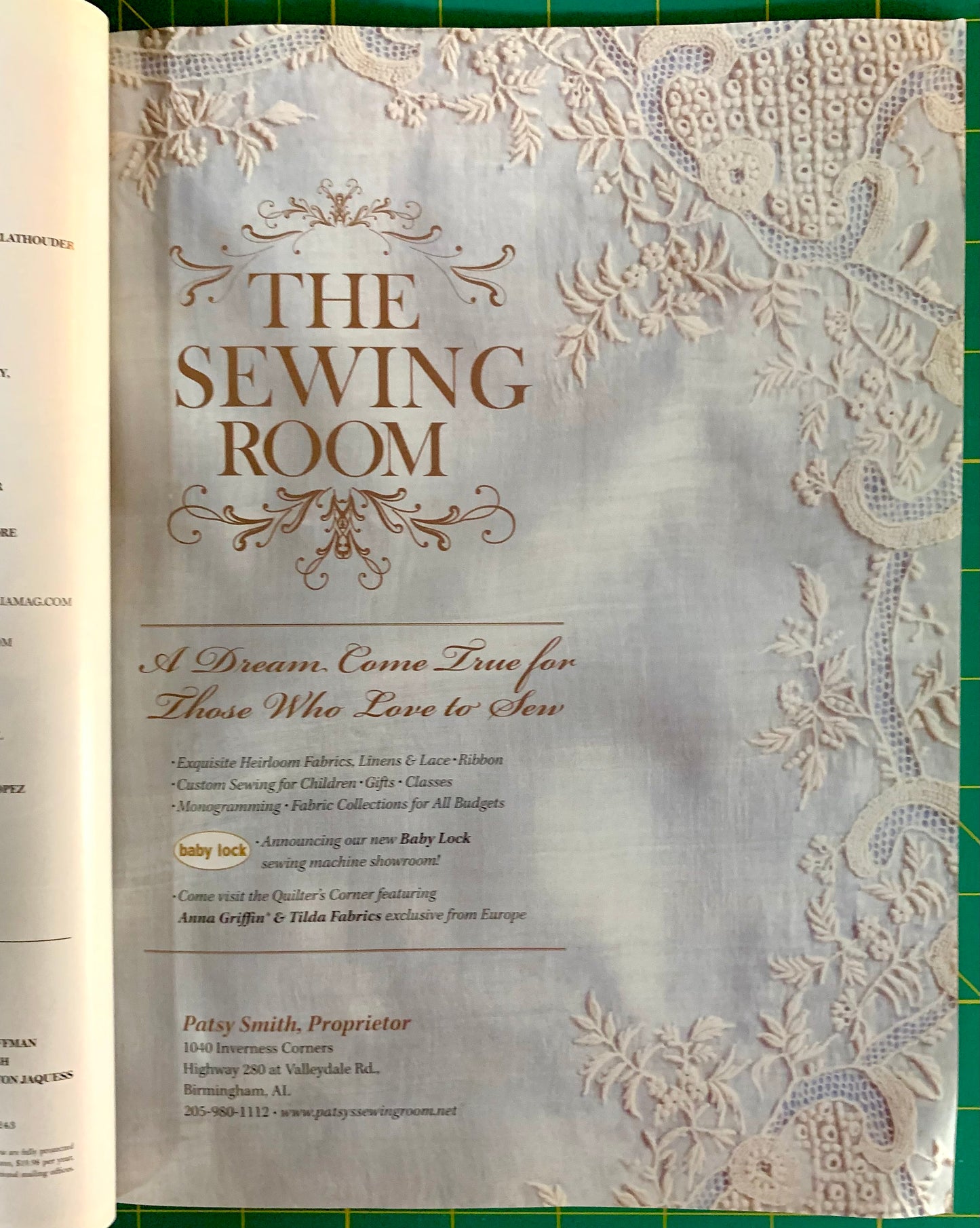 A printed sewing-themed booklet or catalog page titled "THE SEWING ROOM" laid flat on a green cutting mat, with lace-like decorative borders and small text below the title.
[additional_image_link]
