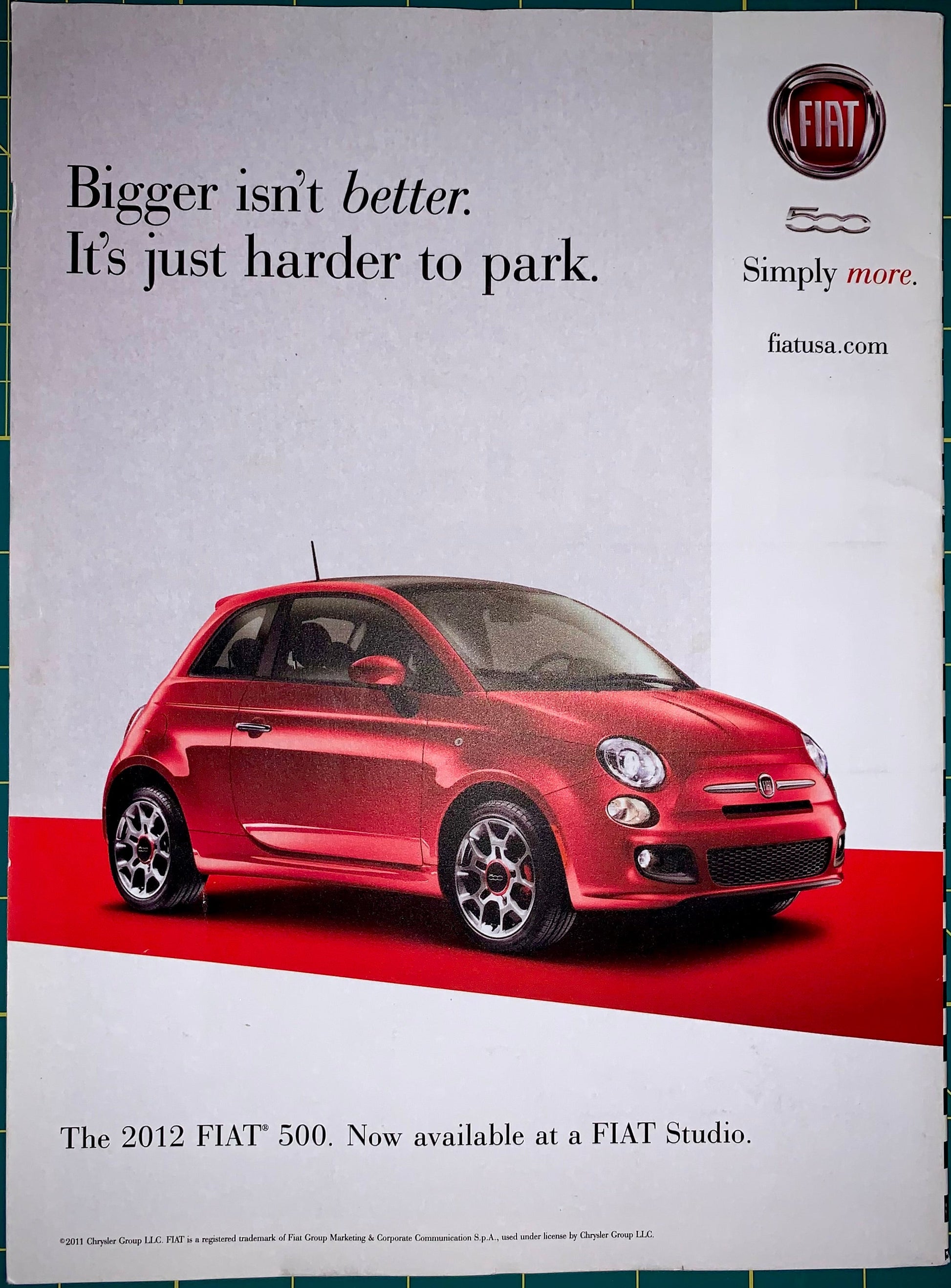 A vintage Fiat advertisement print featuring a red 2012 Fiat 500 car on a white and red background, with the slogan 'Bigger isn't better. It's just harder to park.
[additional_image_link]