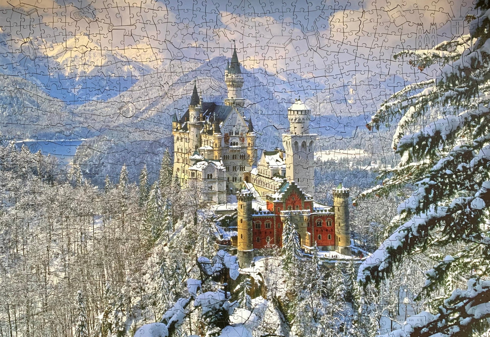 A wooden jigsaw puzzle depicting a winter scene with Neuschwanstein Castle, featuring a mix of shaped and irregular pieces.
Photo by Karen King [image_link]
