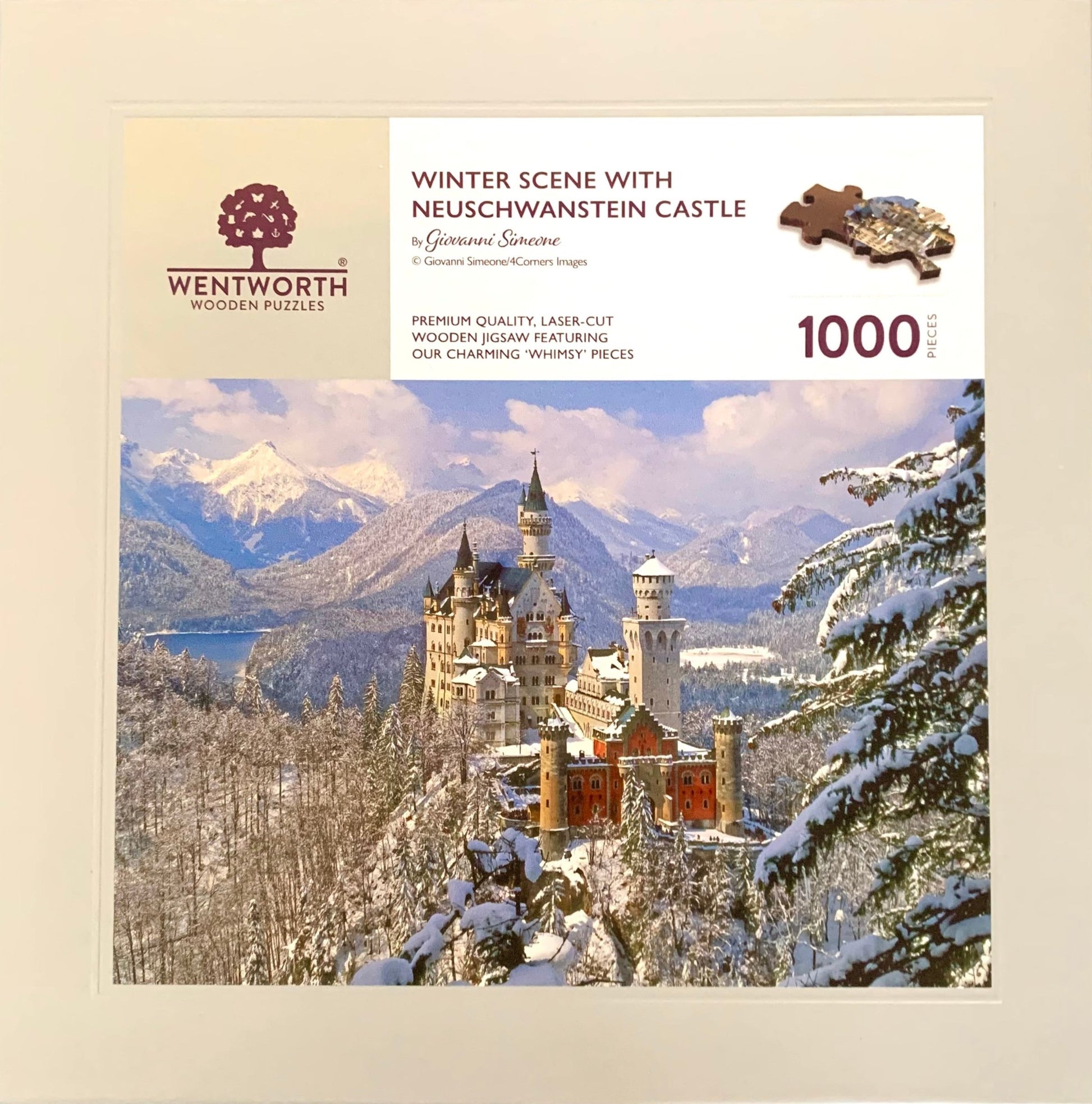 A wooden jigsaw puzzle depicting a winter scene with Neuschwanstein Castle, featuring a mix of shaped and irregular pieces.
Photo by Karen King [additional_image_link]