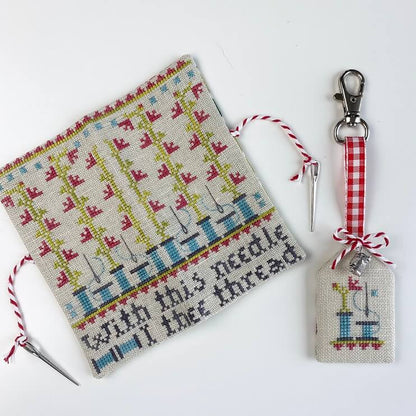A needlework-themed cross-stitch sampler and matching keychain set on a white background. The sampler features a cream linen base with colorful stitched sewing machines and the text 'with this needle I thee thread'.
Photo by HandsOnDesign.biz [image_link]