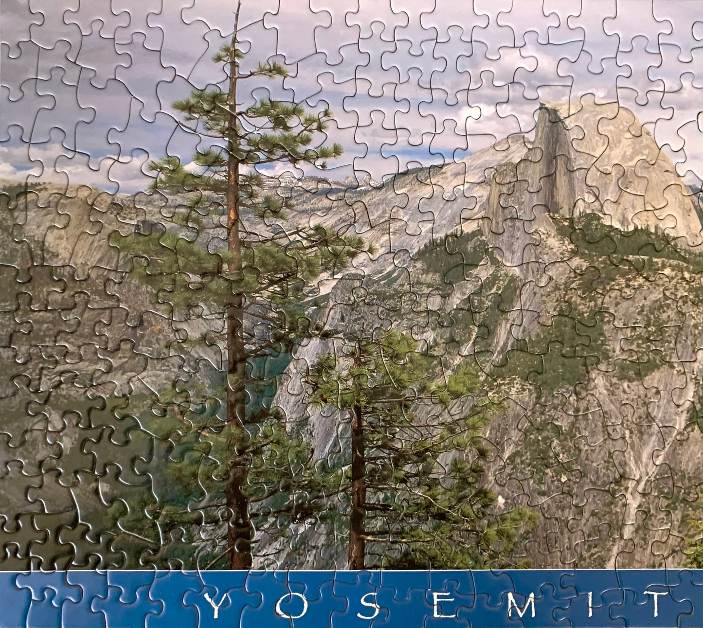 A jigsaw puzzle depicting a panoramic view of Yosemite National Park with green trees and rock formations.
Photo by Karen King [additional_image_link]