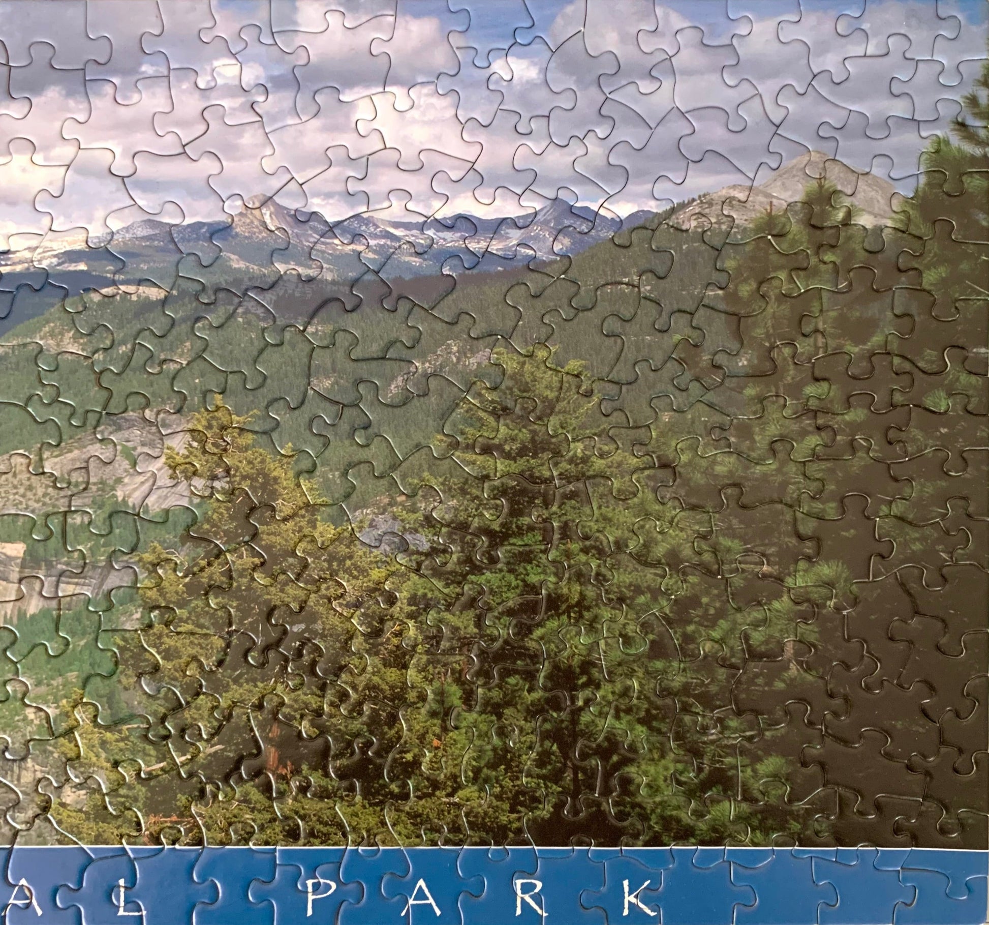 A jigsaw puzzle depicting a panoramic view of Yosemite National Park with green trees and rock formations.
Photo by Karen King [additional_image_link]