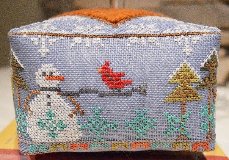 Cross-stitched box with winter scene featuring a snowman, cardinal, and trees.
Photo by HandsOnDesign.biz [additional_image_link]
