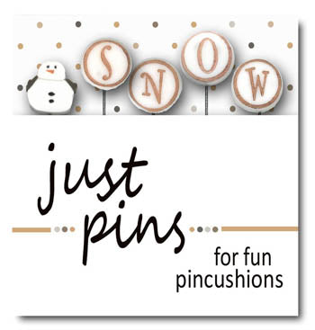 A square white card or sign with decorative holiday text reading 'just pins for fun pincushions' and a snowman illustration above circular letters spelling 'snow'.
Photo by Just Another Button Company [additional_image_link]