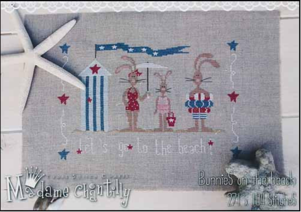 Cross stitch kit depicting three rabbits on a beach background with stars and stripes, likely intended for a craft or embellishment project.
Photo by Madame Chantilly [image_link]