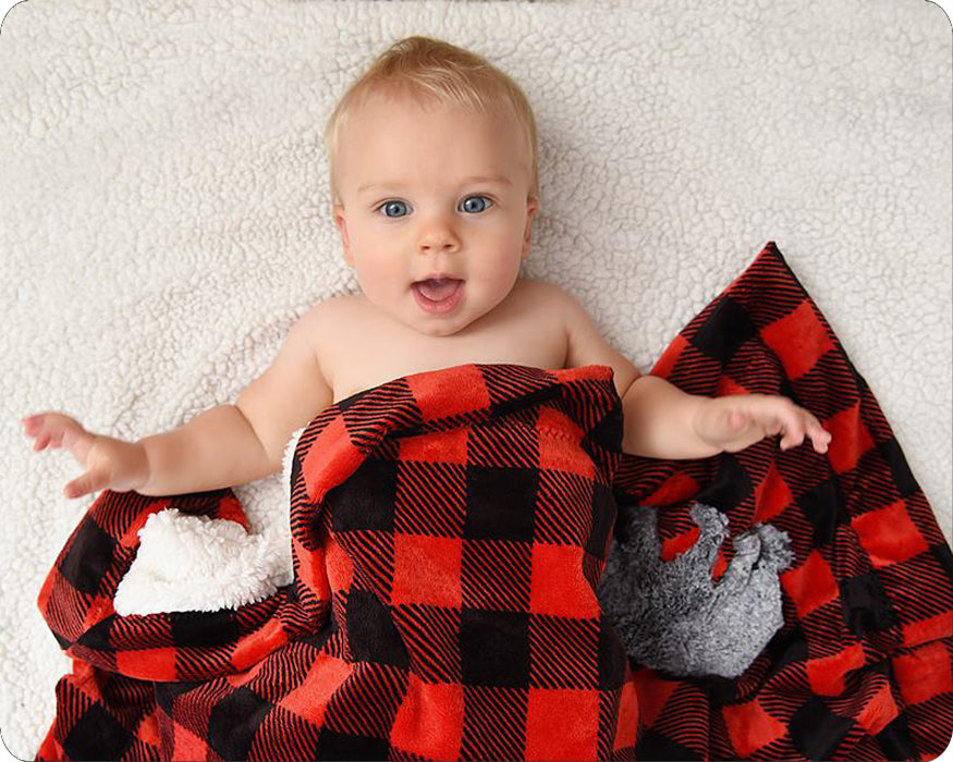 A red and black checkered baby cuddle blanket with a gray bear applique on the bottom right corner on a baby.
Photo by Shannon Fabrics [additional_image_link]