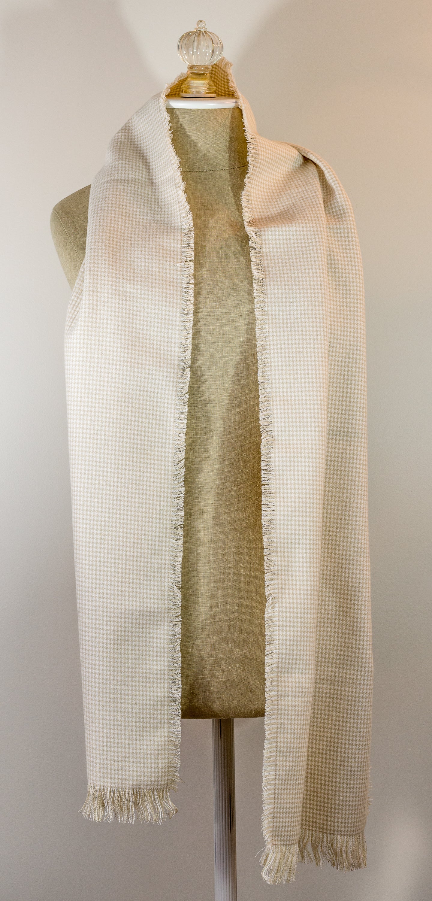 A beige houndstooth flannel scarf displayed on a mannequin, fringed on all sides.
Photo by TheSurgeonsKnots.com [additional_image_link]