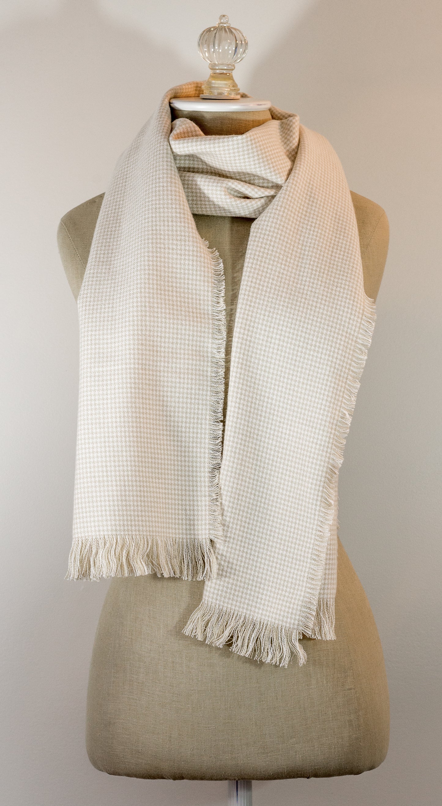 A beige houndstooth flannel scarf displayed on a mannequin, fringed on all sides.
Photo by TheSurgeonsKnots.com [additional_image_link]
