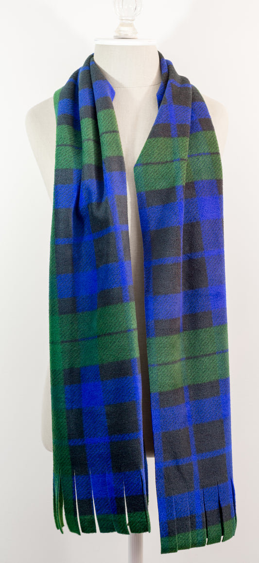 A tartan plaid scarf in green, blue, and black, draped on a white mannequin torso against a white background.
Photo by TheSurgeonsKnots.com [image_link]