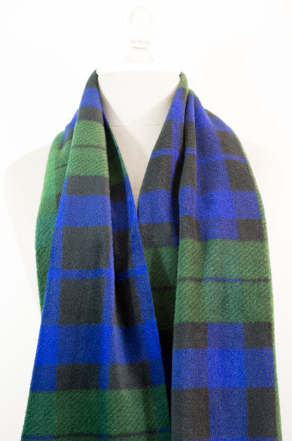 A tartan plaid scarf in green, blue, and black, draped on a white mannequin torso against a white background.
Photo by TheSurgeonsKnots.com [additional_image_link]