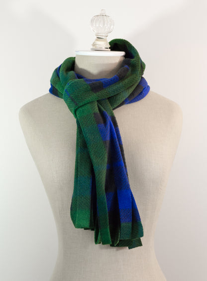 A tartan plaid scarf in green, blue, and black, draped on a white mannequin torso against a white background.
Photo by TheSurgeonsKnots.com [additional_image_link]