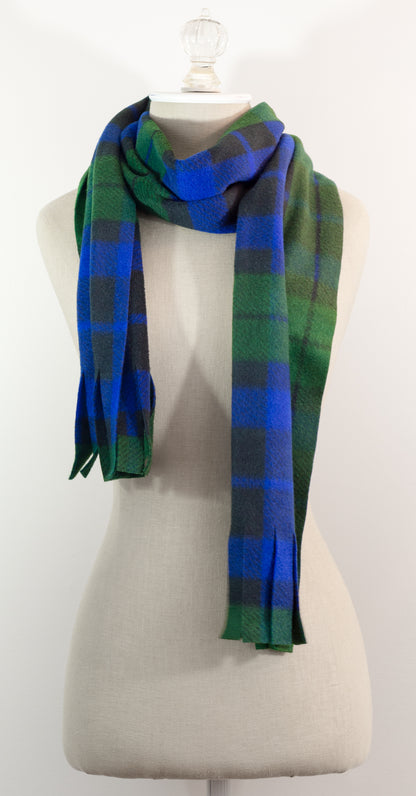 A tartan plaid scarf in green, blue, and black, draped on a white mannequin torso against a white background.
Photo by TheSurgeonsKnots.com [additional_image_link]