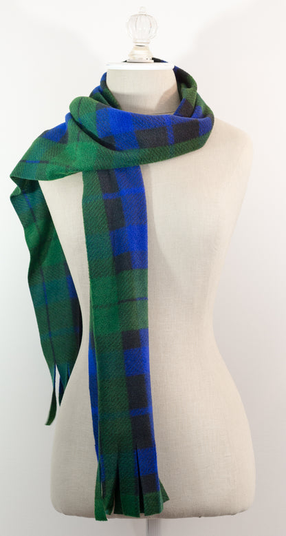 A tartan plaid scarf in green, blue, and black, draped on a white mannequin torso against a white background.
Photo by TheSurgeonsKnots.com [additional_image_link]