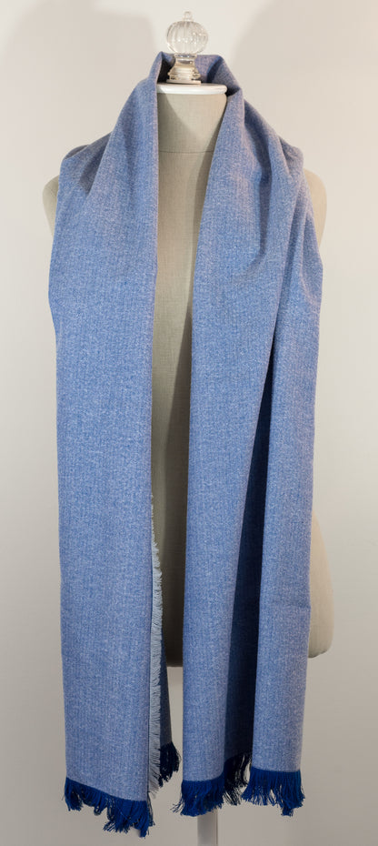 A blue herringbone flannel blanket scarf displayed on a mannequin, with the texture of the fabric visible. It has a fringe and appears to be a warm-colored accessory suitable for winter.
Photo by Karen King  [additional_image_link]