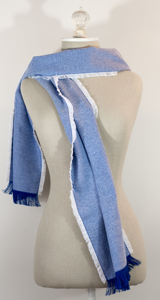 A blue herringbone flannel scarf with hand-frayed edges displayed on a mannequin.
Photo by Karen King [image_link]