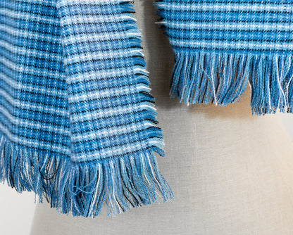 A blue tartan plaid flannel blanket scarf draped over a mannequin bust.
Photo by Karen King  [additional_image_link]