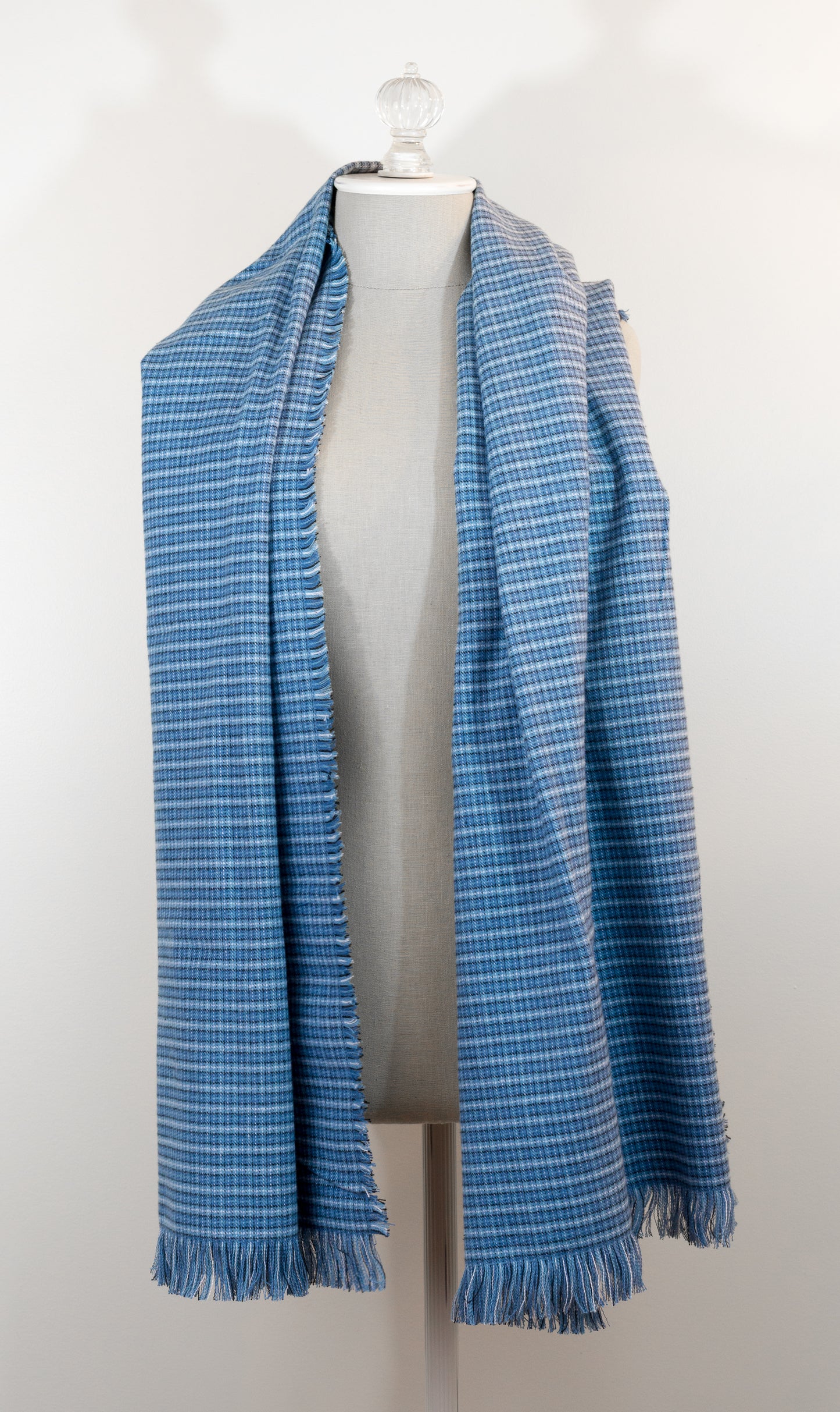 A blue tartan plaid flannel blanket scarf draped over a mannequin bust.
Photo by Karen King  [additional_image_link]