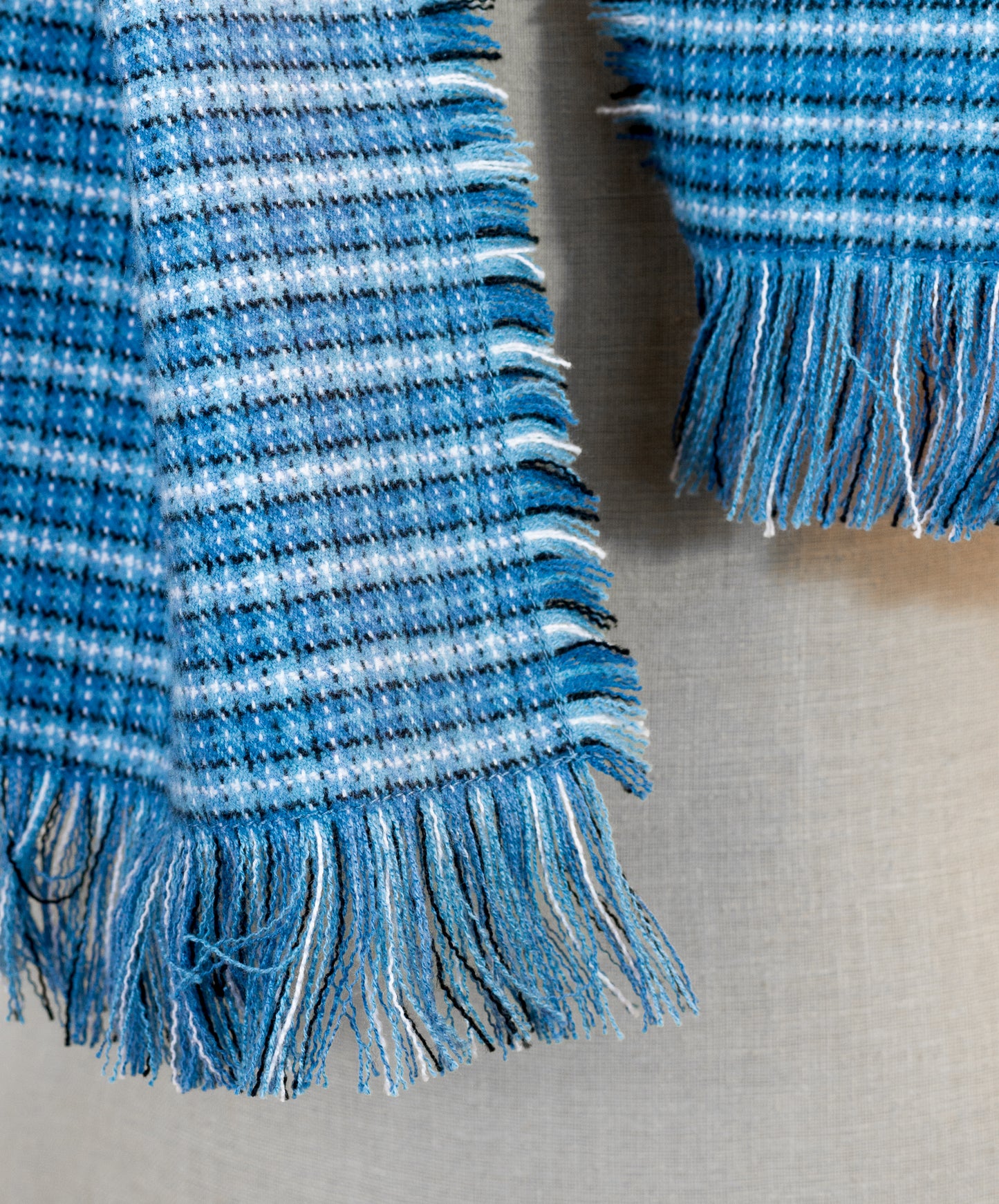 A blue tartan plaid flannel blanket scarf draped over a mannequin bust.
Photo by Karen King  [additional_image_link]