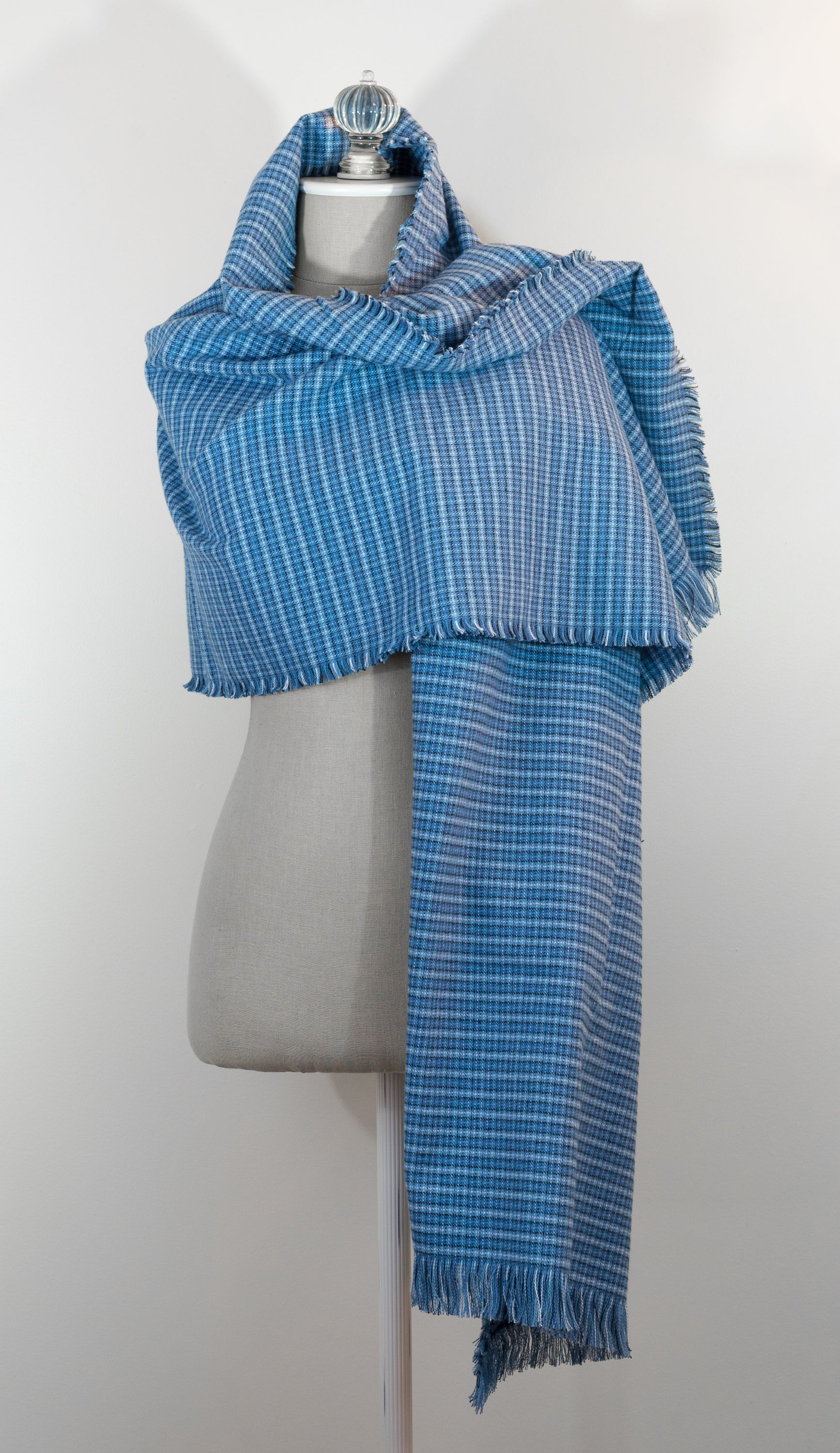 A blue tartan plaid flannel blanket scarf draped over a mannequin bust.
Photo by Karen King  [additional_image_link]