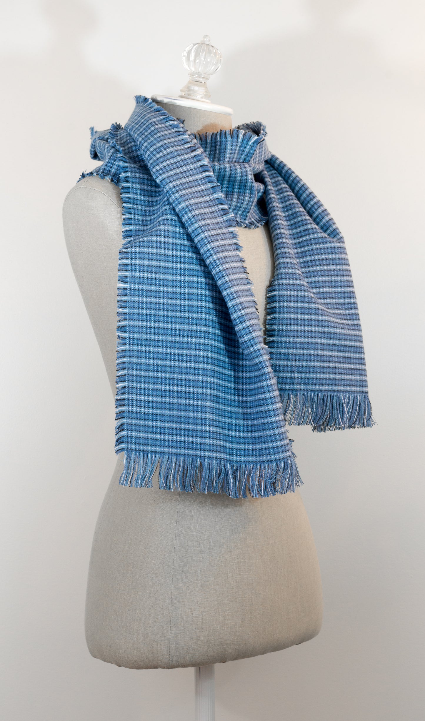 A blue tartan plaid flannel blanket scarf draped over a mannequin bust.
Photo by Karen King  [additional_image_link]