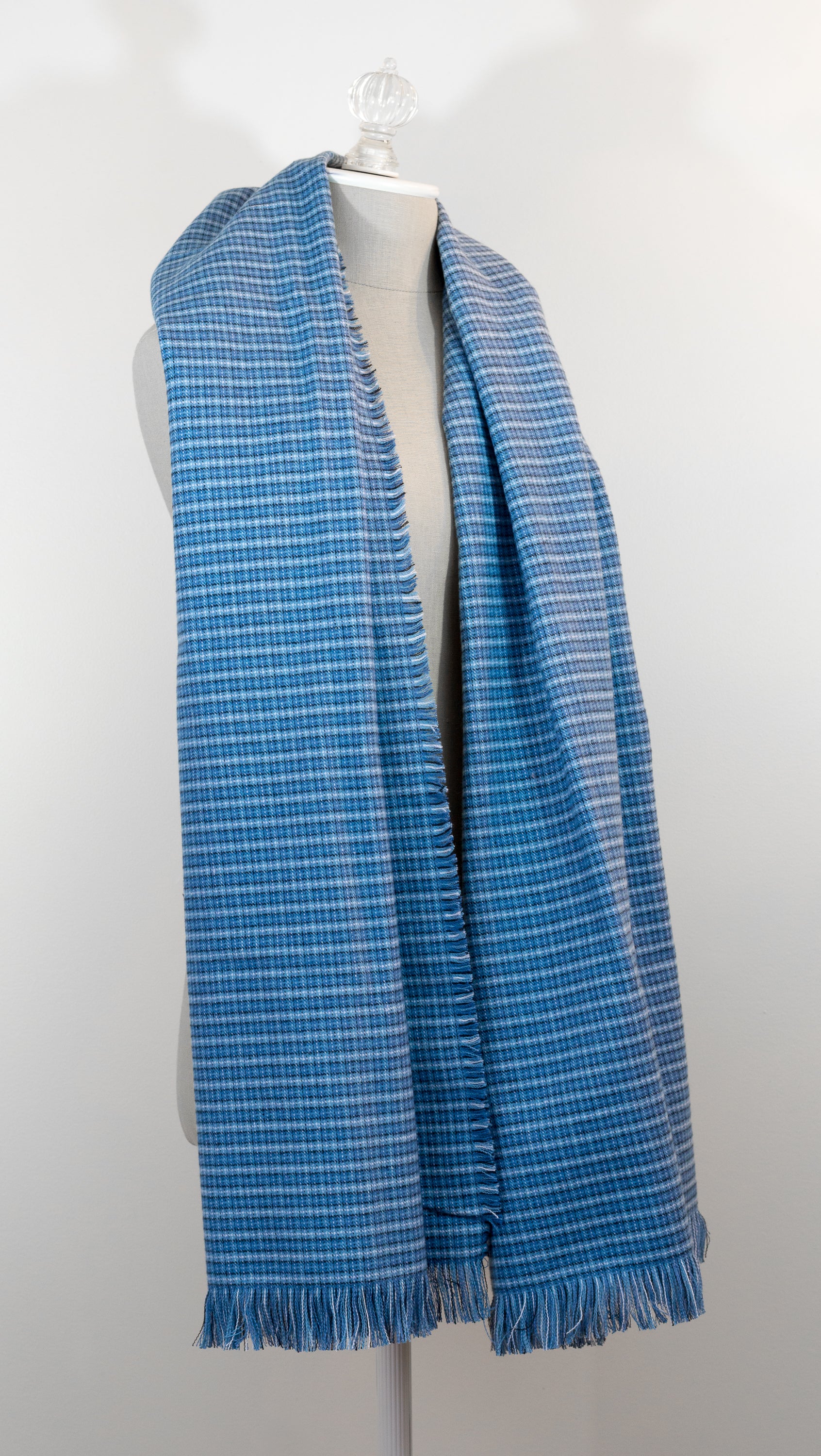 A blue tartan plaid flannel blanket scarf draped over a mannequin bust.
Photo by Karen King  [additional_image_link]