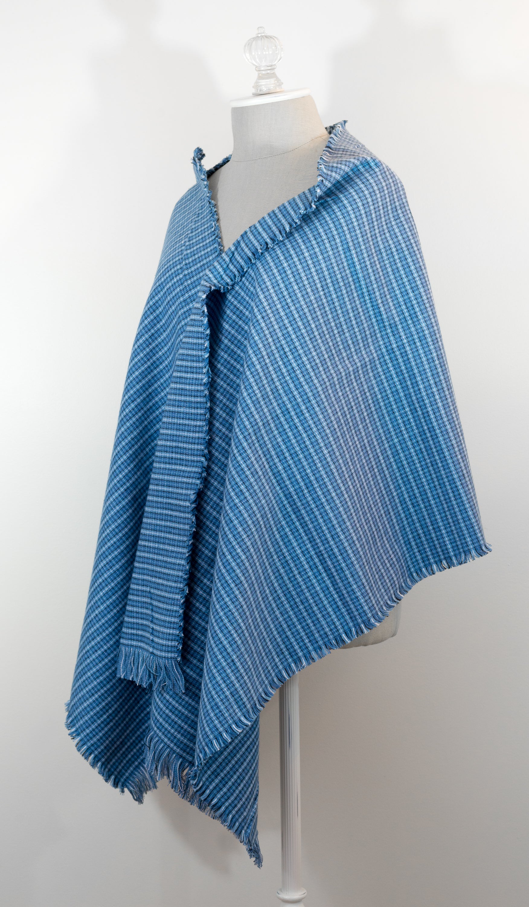 A blue tartan plaid flannel blanket scarf draped over a mannequin bust.
Photo by Karen King  [additional_image_link]