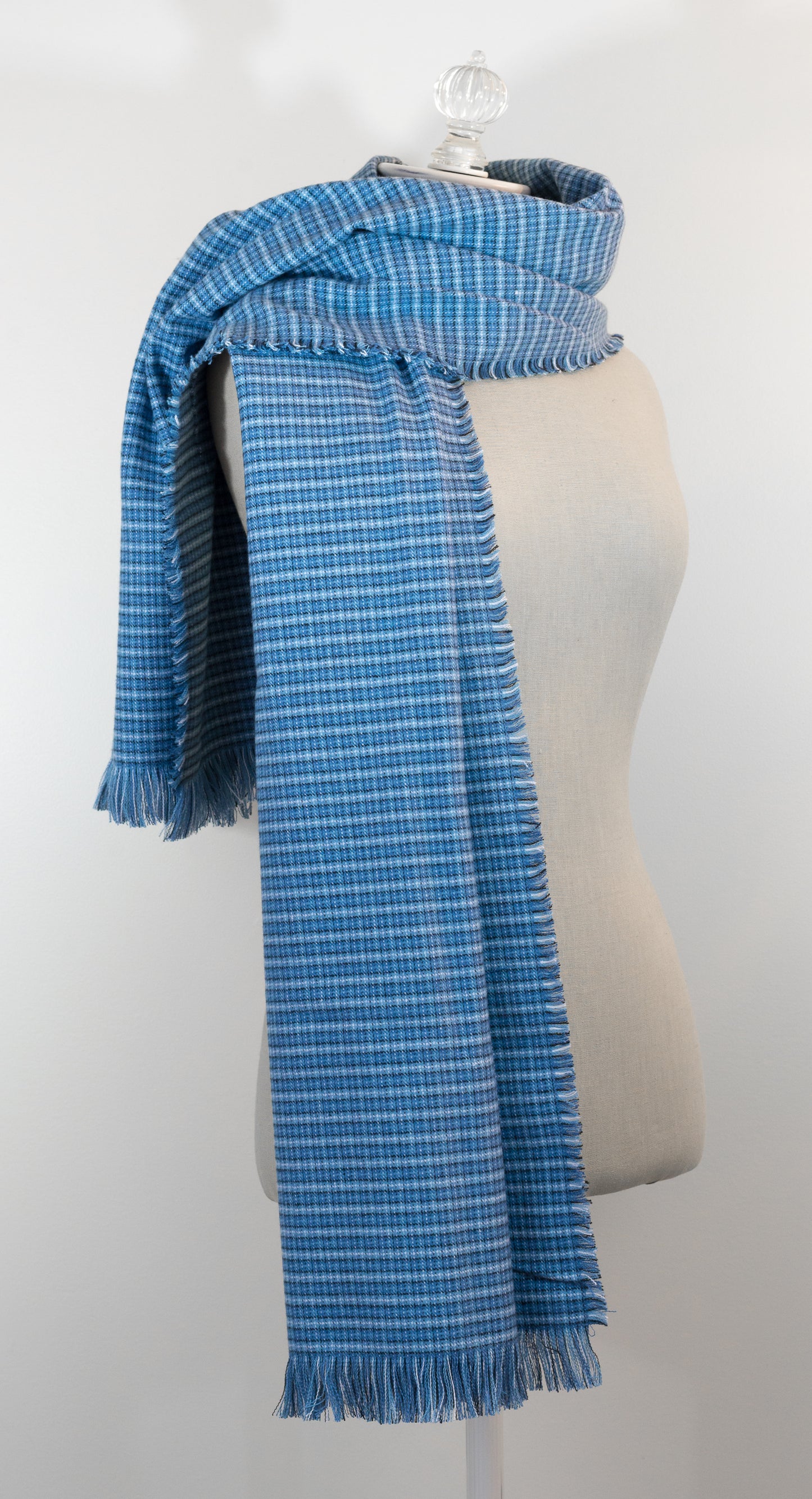A blue tartan plaid flannel blanket scarf draped over a mannequin bust.
Photo by Karen King  [additional_image_link]