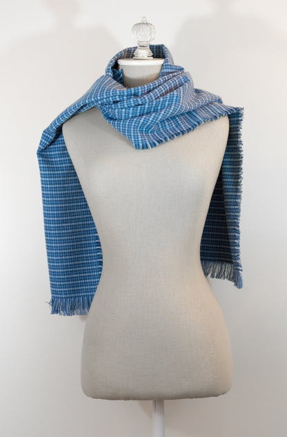 A blue tartan plaid flannel scarf displayed on a mannequin, with fringe detailing on the ends.
Photo by Karen King [additional_image_link]