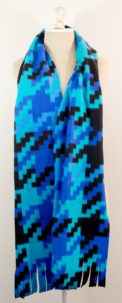 A scarf with a geometric houndstooth pattern in shades of blue and black, displayed on a mannequin.
Photo by Karen King [additional_image_link]
