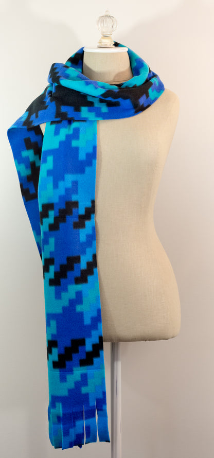 A scarf with a geometric houndstooth pattern in shades of blue and black, displayed on a mannequin.
Photo by Karen King [additional_image_link]