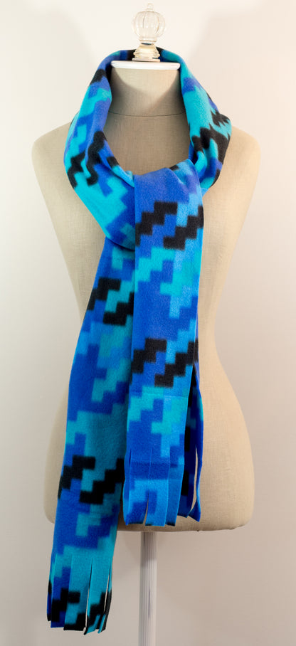 A scarf with a geometric houndstooth pattern in shades of blue and black, displayed on a mannequin.
Photo by Karen King [additional_image_link]