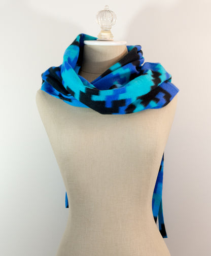 A scarf with a geometric houndstooth pattern in shades of blue and black, displayed on a mannequin.
Photo by Karen King [additional_image_link]