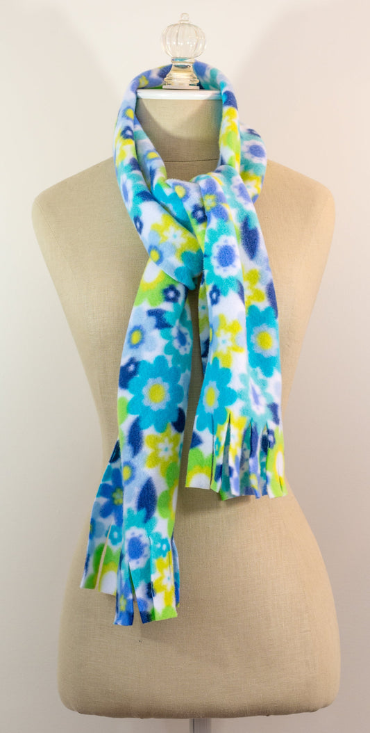 A blue and yellow floral polar fleece scarf with fringe displayed on a mannequin.
Photo by Karen King [image_link]