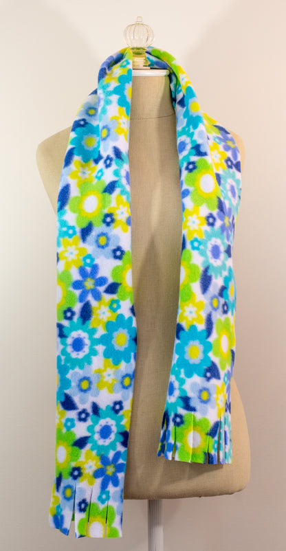 A blue and yellow floral polar fleece scarf with fringe displayed on a mannequin.
Photo by Karen King [additional_image_link]